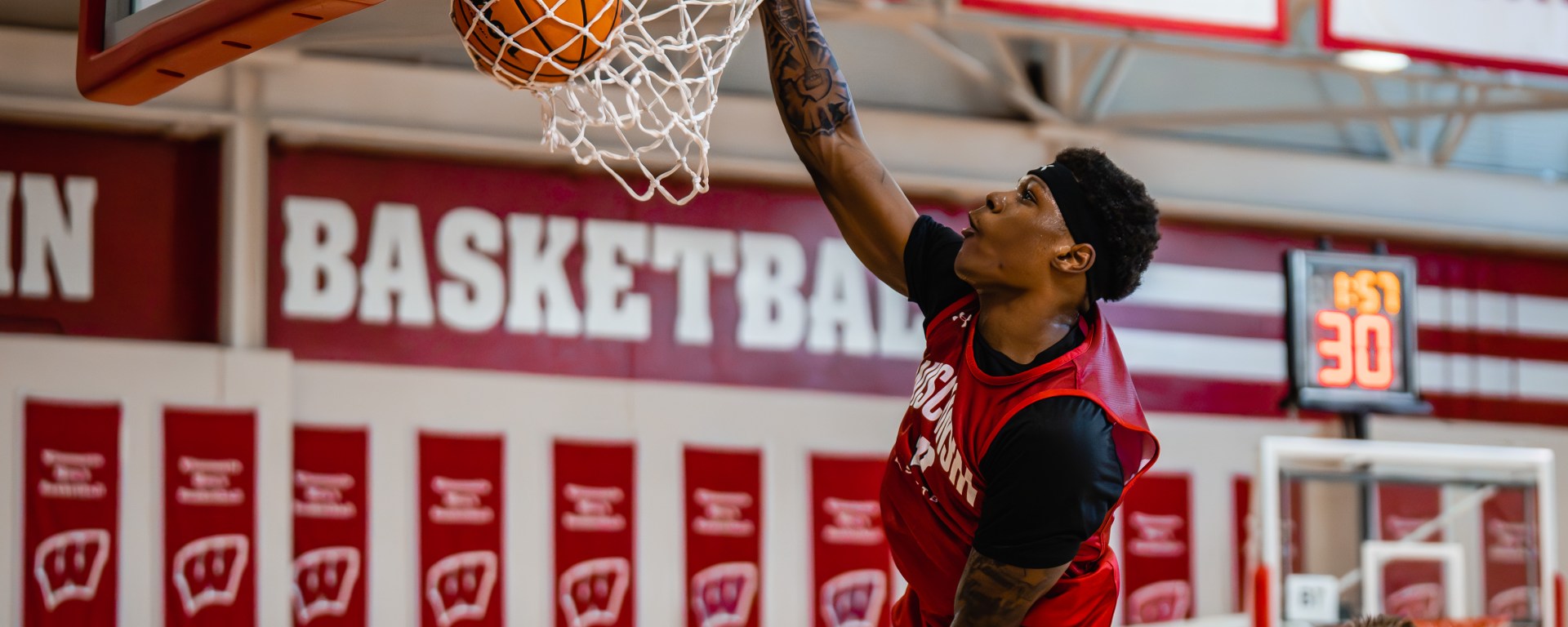A photo of AJ Storr throwing down a one handed dunk in practice.