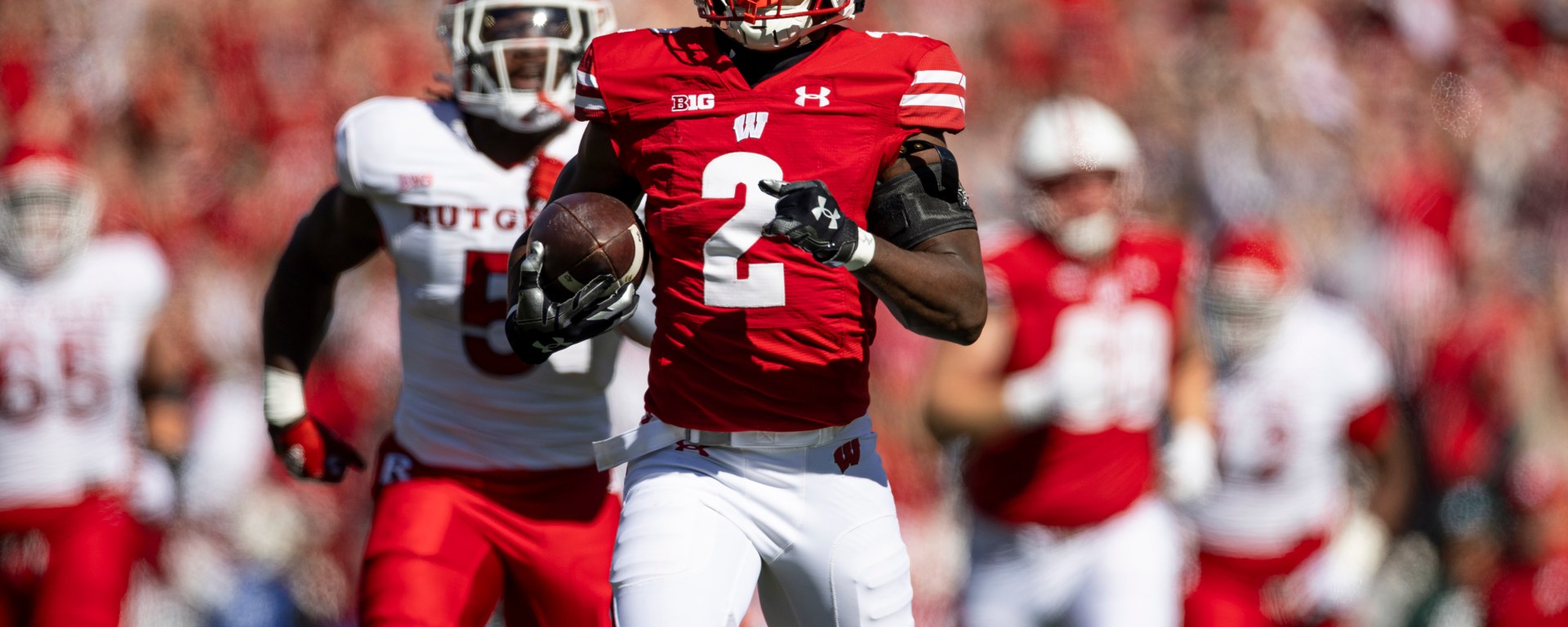 Ricardo Hallman carries the football in front of a Rutgers defender.