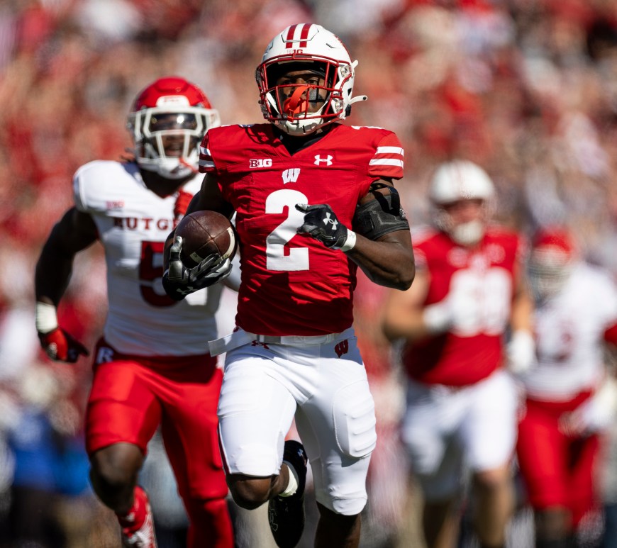 Ricardo Hallman carries the football in front of a Rutgers defender.