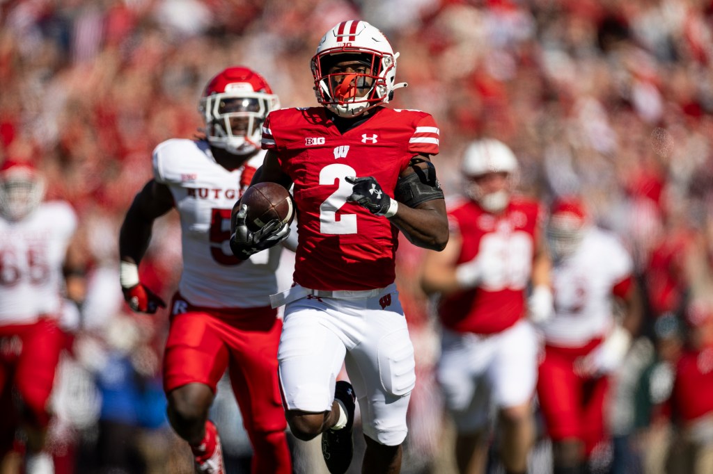 Ricardo Hallman carries the football in front of a Rutgers defender.