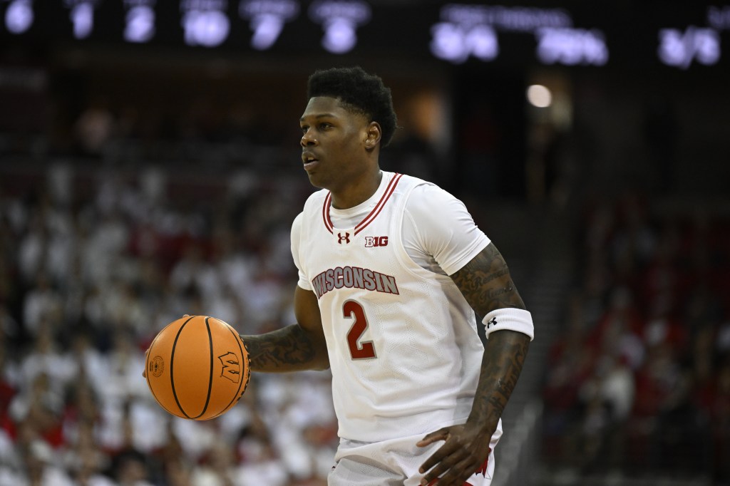 AJ Storr dribbles the ball at the top of the key.