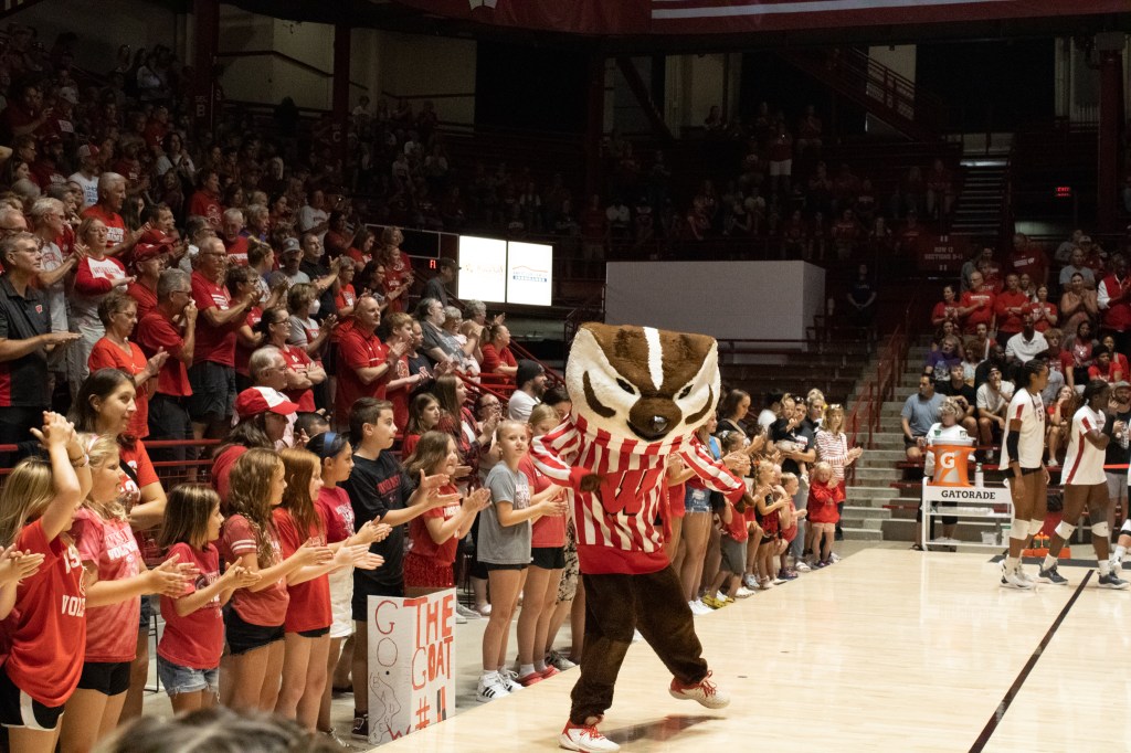 Bucky Badger celebrates with fans during an exhibition game.
